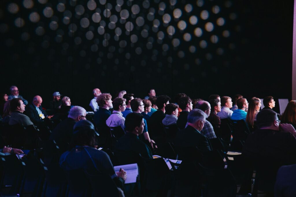 Público reunido en un salón durante una convención comunitaria