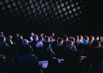 Público reunido en un salón durante una convención comunitaria