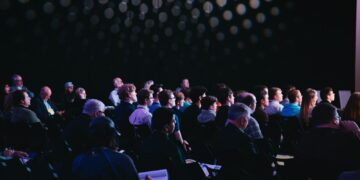 Público reunido en un salón durante una convención comunitaria