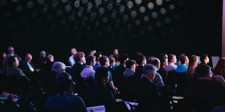 Público reunido en un salón durante una convención comunitaria
