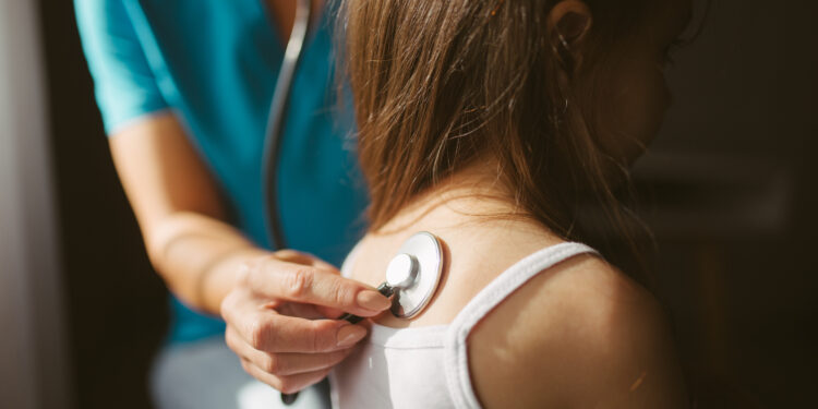 Una doctora ausculta a un paciente con un estetoscopio, relacionado con el acceso a la salud