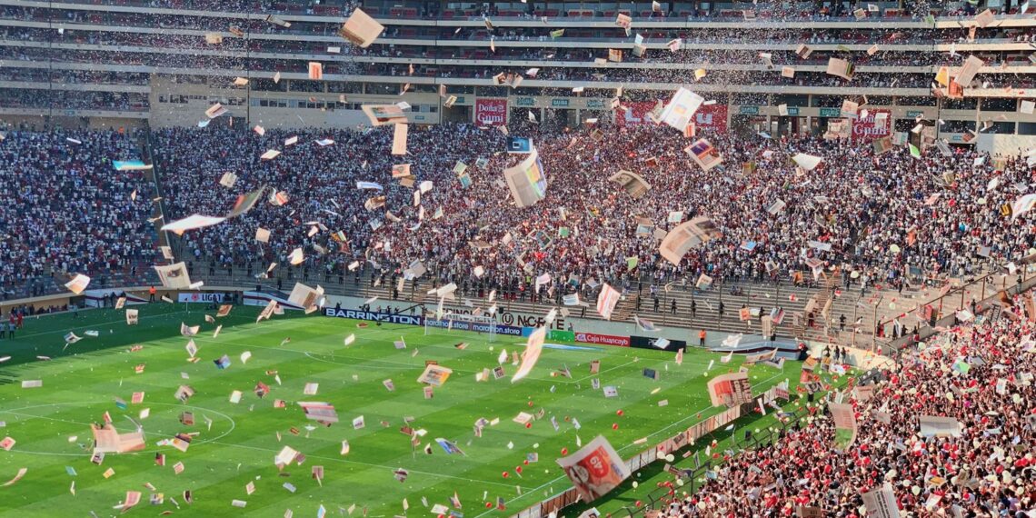 Estadio de fútbol repleto de aficionados durante un partido