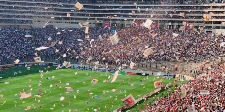 Estadio de fútbol repleto de aficionados durante un partido