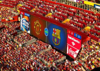 Jugadores y aficionados durante un partido de fútbol en un estadio