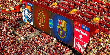 Jugadores y aficionados durante un partido de fútbol en un estadio