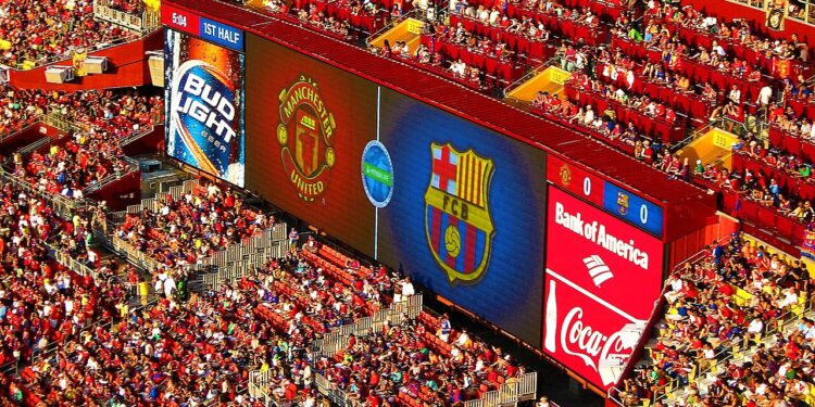 Jugadores y aficionados durante un partido de fútbol en un estadio