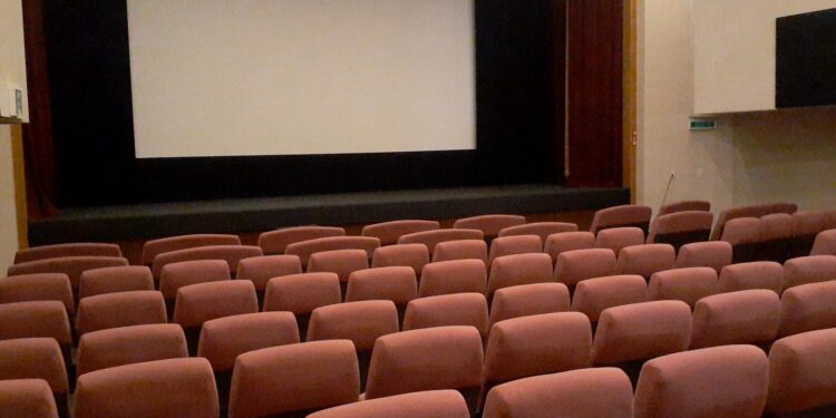 Interior de una sala de cine con butacas y pantalla