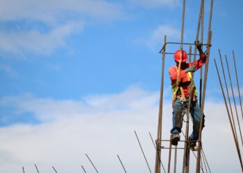 Trabajador de la construcción con casco rojo durante una jornada calurosa