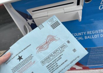 Una boleta electoral junto a una urna de votación en Estados Unidos