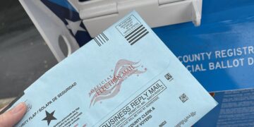 Una boleta electoral junto a una urna de votación en Estados Unidos