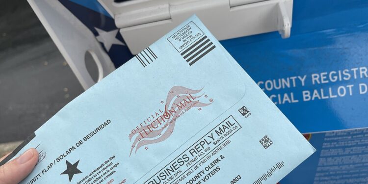 Una boleta electoral junto a una urna de votación en Estados Unidos