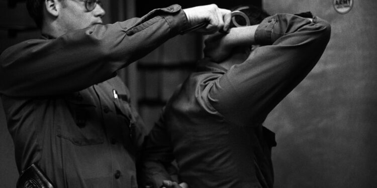 Un agente policial coloca esposas a un detenido durante un operativo