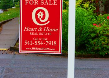 Letrero de casa en venta frente a una vivienda
