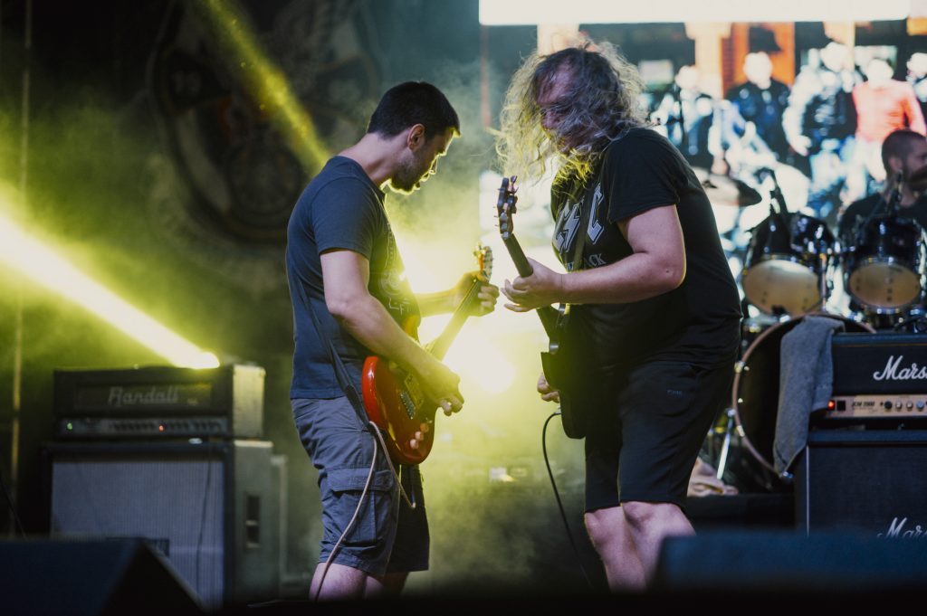 Artistas en un escenario durante un festival de música con público
