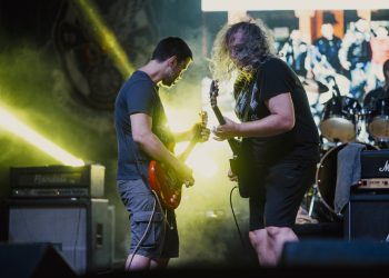 Artistas en un escenario durante un festival de música con público
