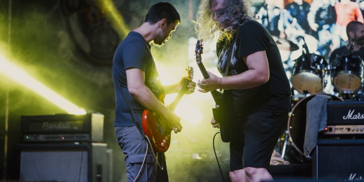 Artistas en un escenario durante un festival de música con público