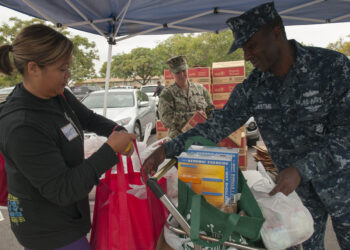 Voluntarios distribuyen alimentos en un banco de comida