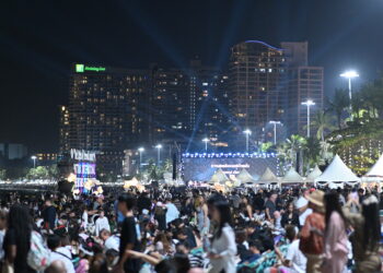Miles de personas frente a un escenario iluminado durante un concierto al aire libre