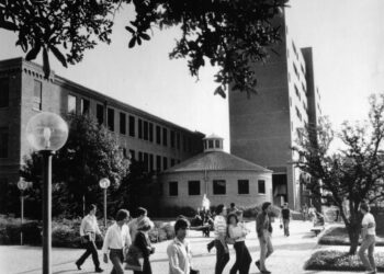 Estudiantes caminan frente a una fuente en el campus de la Universidad de Texas en Arlington