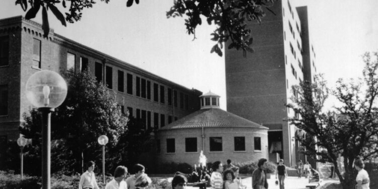 Estudiantes caminan frente a una fuente en el campus de la Universidad de Texas en Arlington