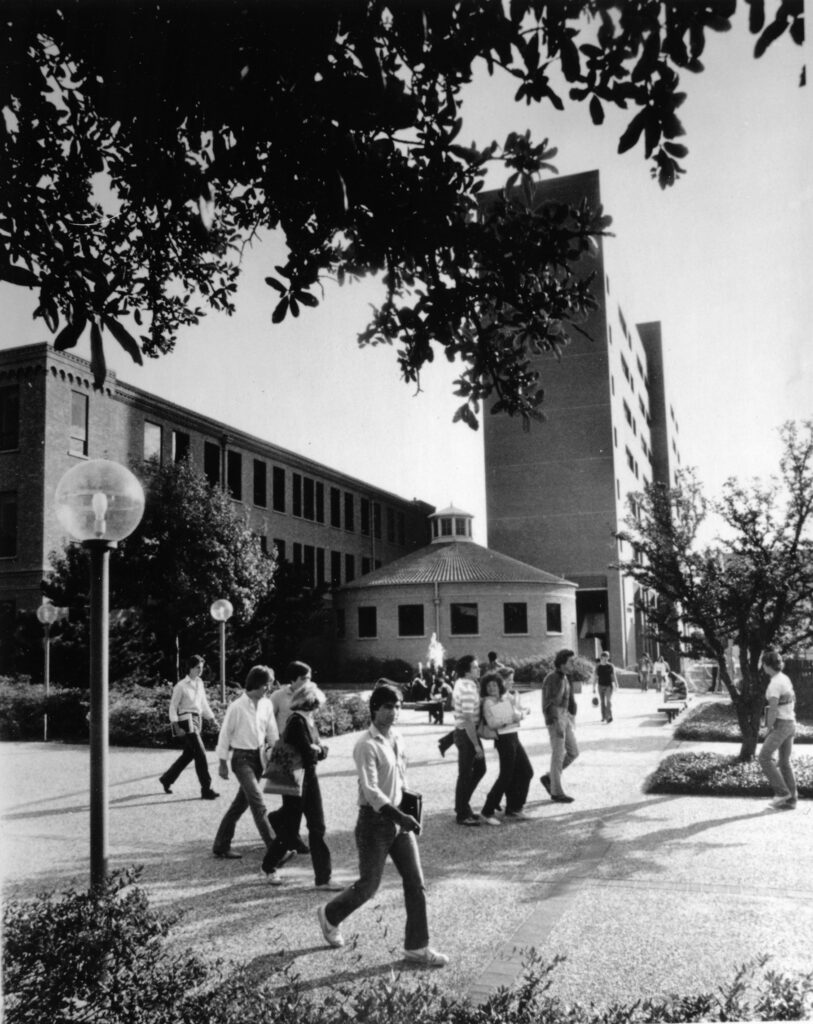 Estudiantes caminan frente a una fuente en el campus de la Universidad de Texas en Arlington