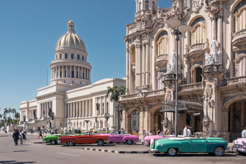 Vista del Capitolio Nacional y autos clásicos en una calle de La Habana, Cuba
