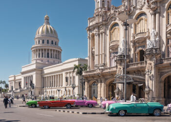 Vista del Capitolio Nacional y autos clásicos en una calle de La Habana, Cuba