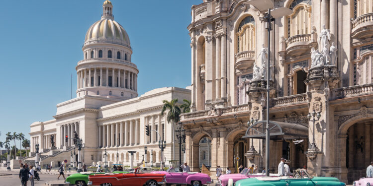 Vista del Capitolio Nacional y autos clásicos en una calle de La Habana, Cuba