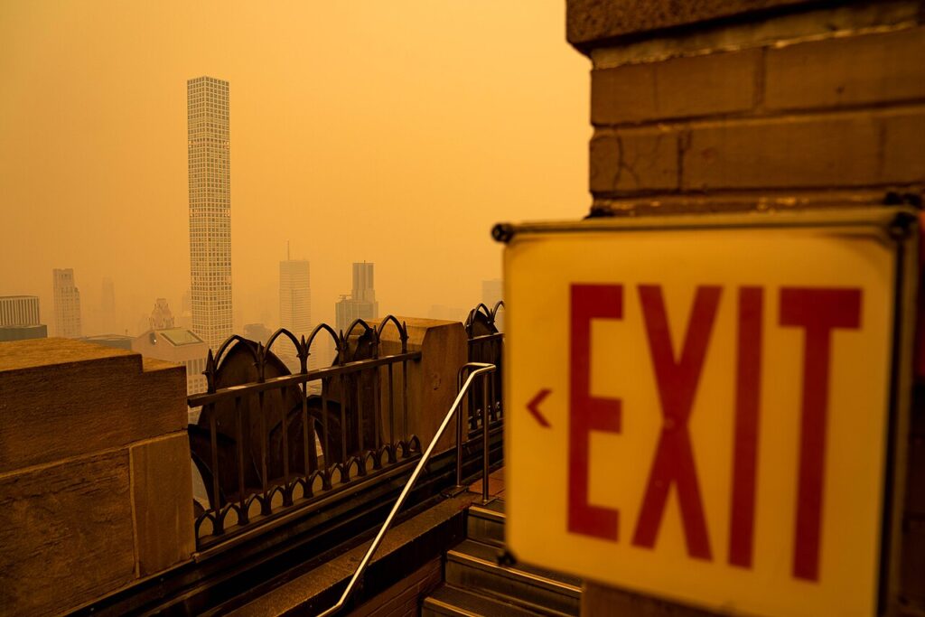 Humo anaranjado de incendios forestales cubre el horizonte de una ciudad estadounidense