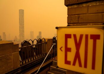 Humo anaranjado de incendios forestales cubre el horizonte de una ciudad estadounidense