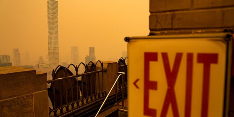 Humo anaranjado de incendios forestales cubre el horizonte de una ciudad estadounidense