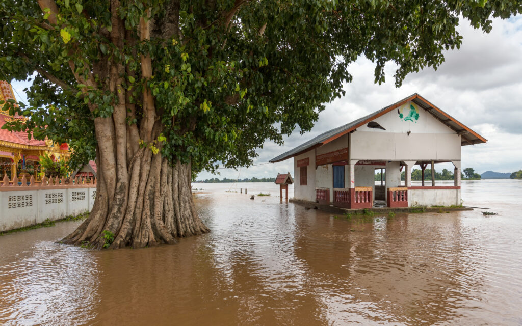 Edificio y árboles rodeados por las aguas de una inundación