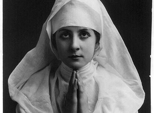 Mujer con hábito religioso en actitud de oración