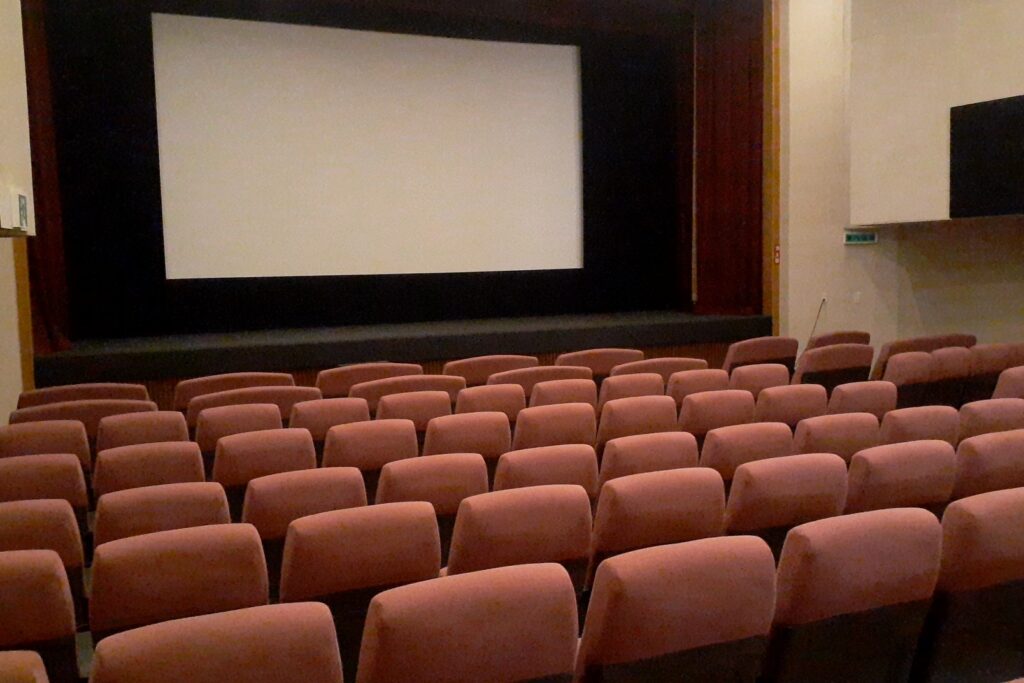Interior de una sala de cine con butacas y pantalla