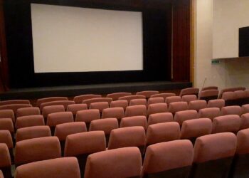 Interior de una sala de cine con butacas y pantalla