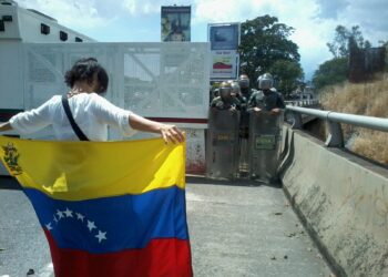 Persona con la bandera de Venezuela durante una manifestación
