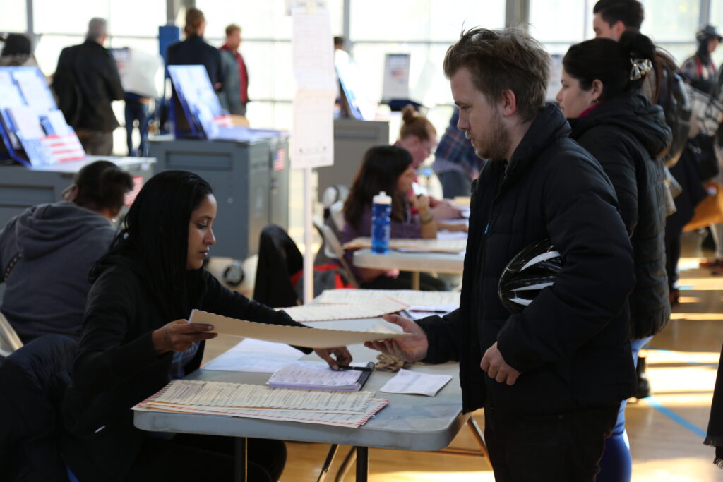 Un votante recibe su boleta en un centro de votación durante una elección en Estados Unidos