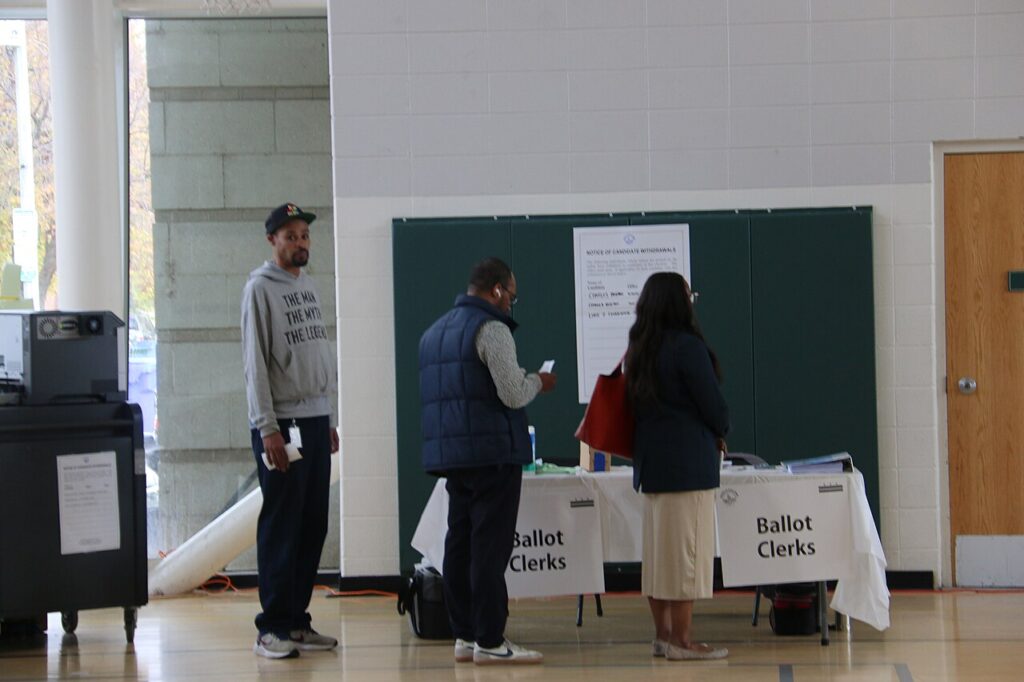 Votantes reciben sus boletas electorales en un centro de votación en Estados Unidos