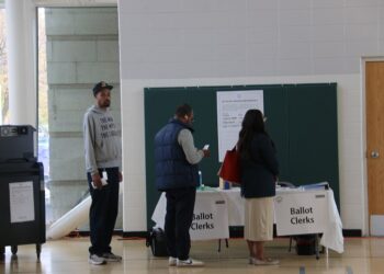 Votantes reciben sus boletas electorales en un centro de votación en Estados Unidos