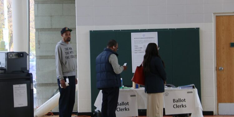 Votantes reciben sus boletas electorales en un centro de votación en Estados Unidos