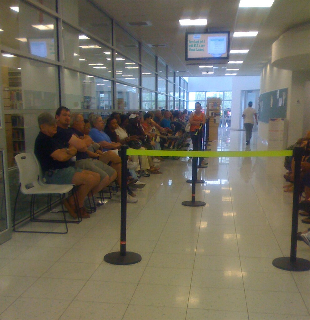 Votantes esperan sentados dentro de un centro de votación
