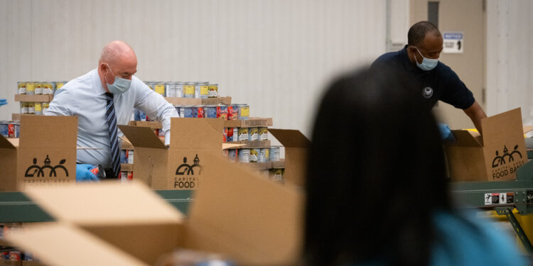 Voluntarios organizan alimentos en un banco de comida