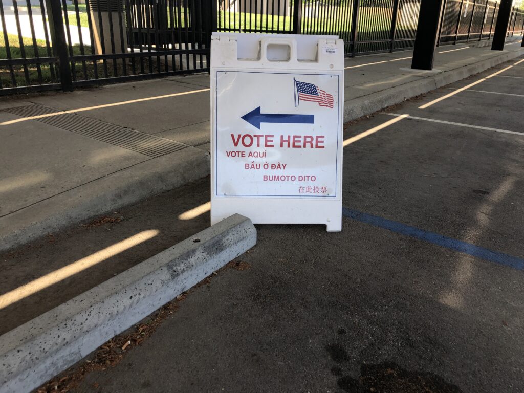 Letrero de centro de votación (Vote Here) frente a un centro comunitario en California