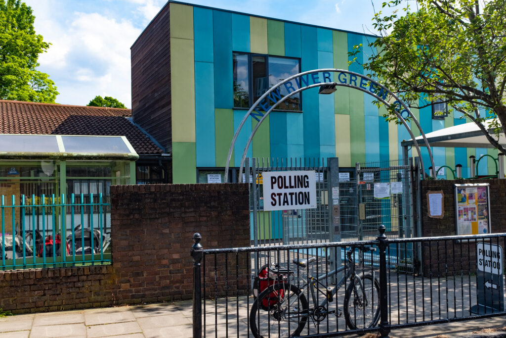 Cartel que indica la entrada a un centro de votación durante unas elecciones