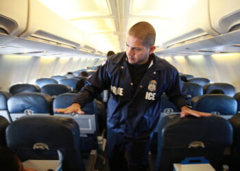 Oficial de deportación de ICE a bordo de un avión de ICE Air