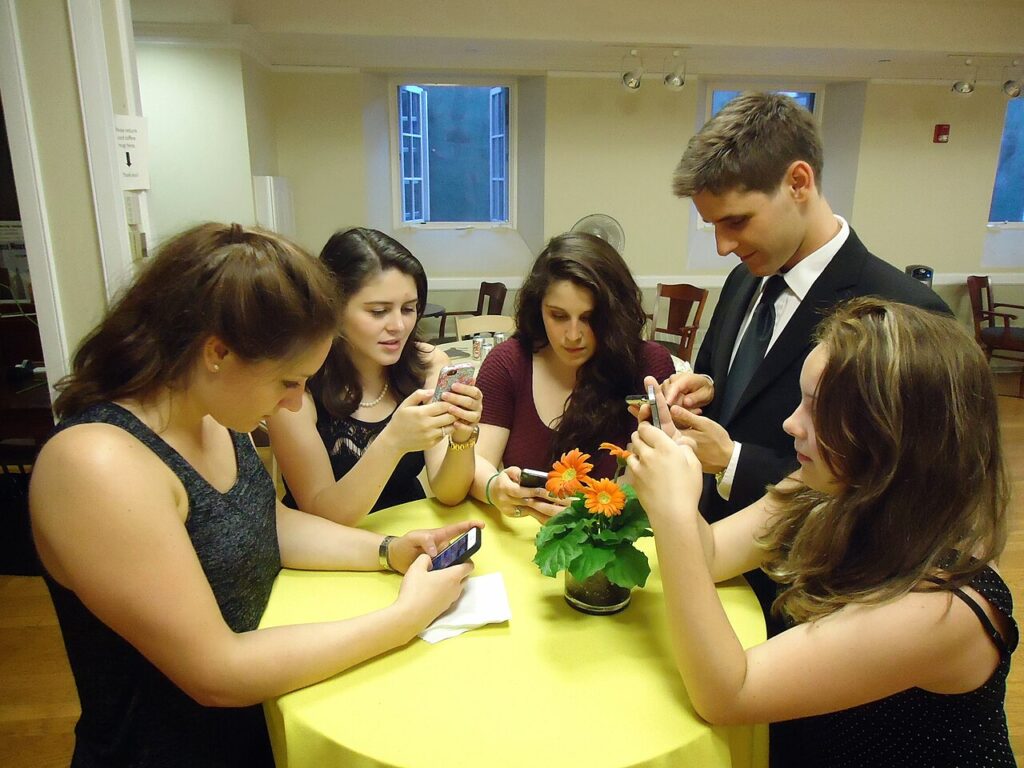 Grupo de jóvenes usando teléfonos inteligentes y redes sociales