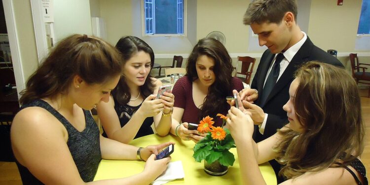 Grupo de jóvenes usando teléfonos inteligentes y redes sociales