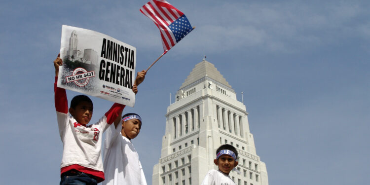 Personas marchan por los derechos de los inmigrantes con pancartas