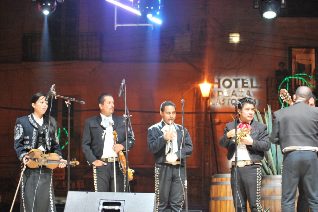 Integrantes de un grupo de mariachi interpretando música mexicana en un festival