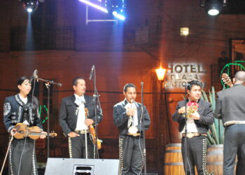 Integrantes de un grupo de mariachi interpretando música mexicana en un festival